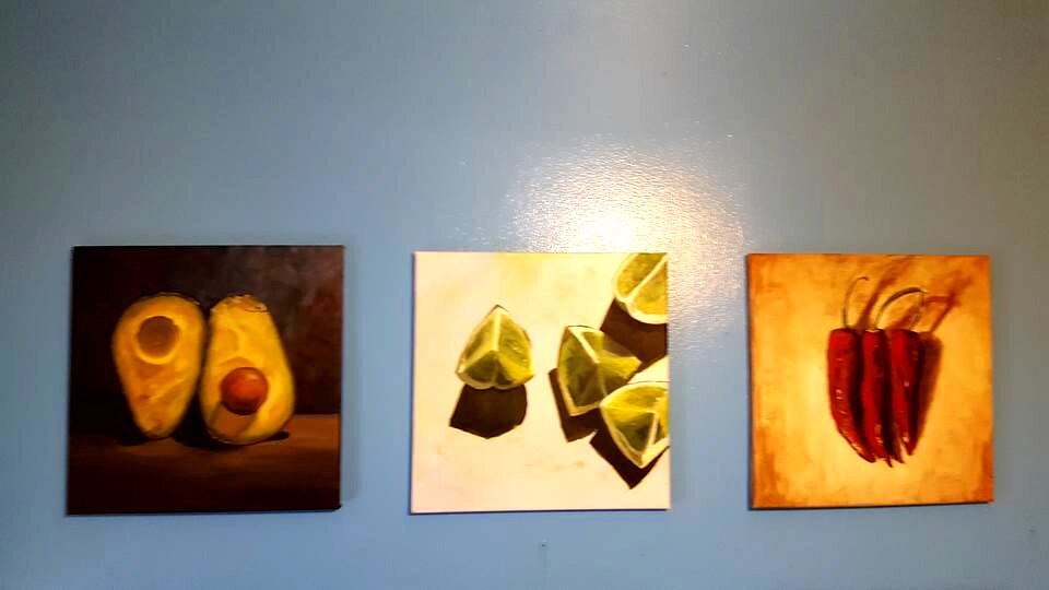 Triptych of food paintings in kitchen
